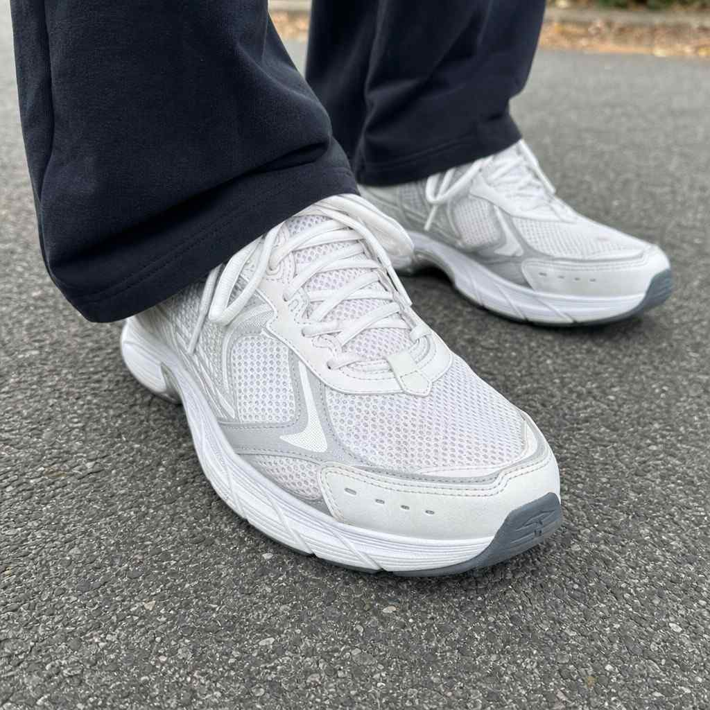 Close-up of supportive walking shoes on a paved path